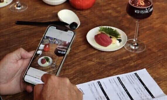 Mobiele telefoon maakt foto van hapje en drankje tijdens Wild Festival Groningen