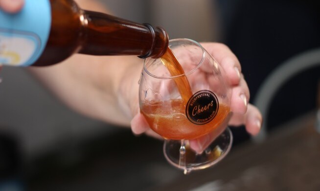 Inzoomen op het inschenken van een flesje bier in een Cheers bierfestival glas