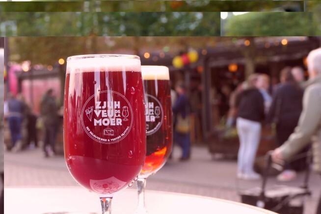 Twee glazen ambachtelijk bier met bezoekers op de achtergrond van het Bierfestival Wintereditie.