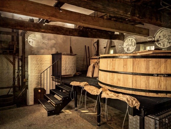 Historisch brouwen in Geleen met grote houten ketels en een trapje, een blik op de brouwerijtradities.