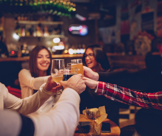 Vriendengroep die proost met bier in een bar