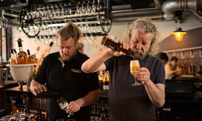 Twee mannen schenken bier in een bar tijdens een evenement.