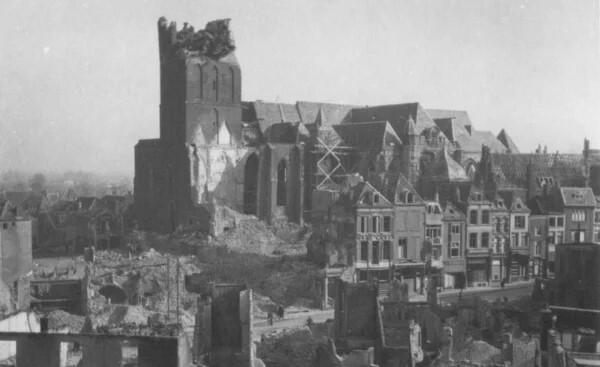 Zwart-wit afbeelding van beschadigde kerk en gebouwen in Nijmegen na bombardement.