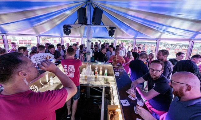 Festivalgangers drinken bier en praten bij een drukke bar op Rigters Speciaalbier Festival 2026.