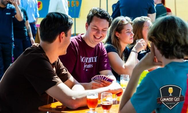 Mensen lachend rond een tafel met glazen speciaalbier op het Gimmert Gist Festival.