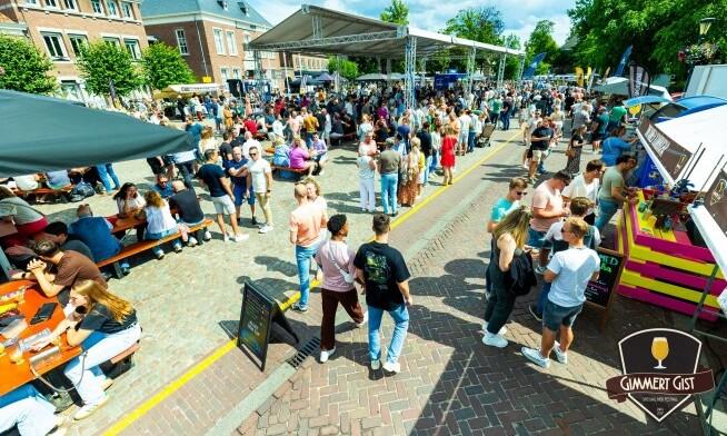 Drukke bierfestival markt met mensen en kraampjes op een zonnige dag.