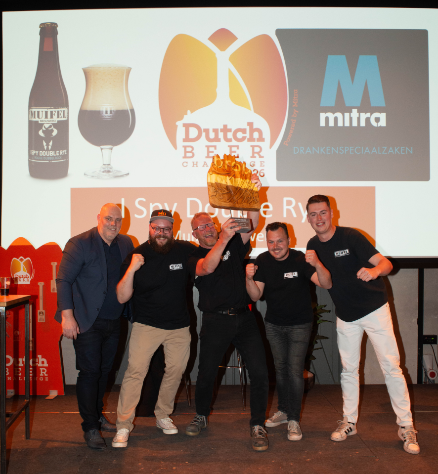 Team van Muifelbrouwerij viert een bierprijs met een trofee op een podium.