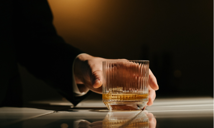 Man pakt glas whisky van de bar