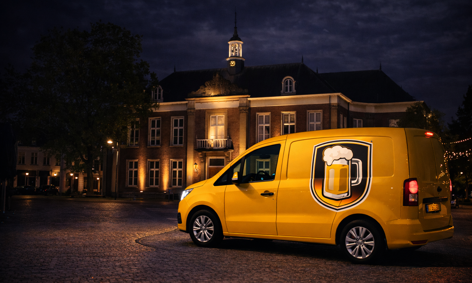 Geel bestelbusje met bierglaslogo voor verlicht historisch gebouw in de avond.