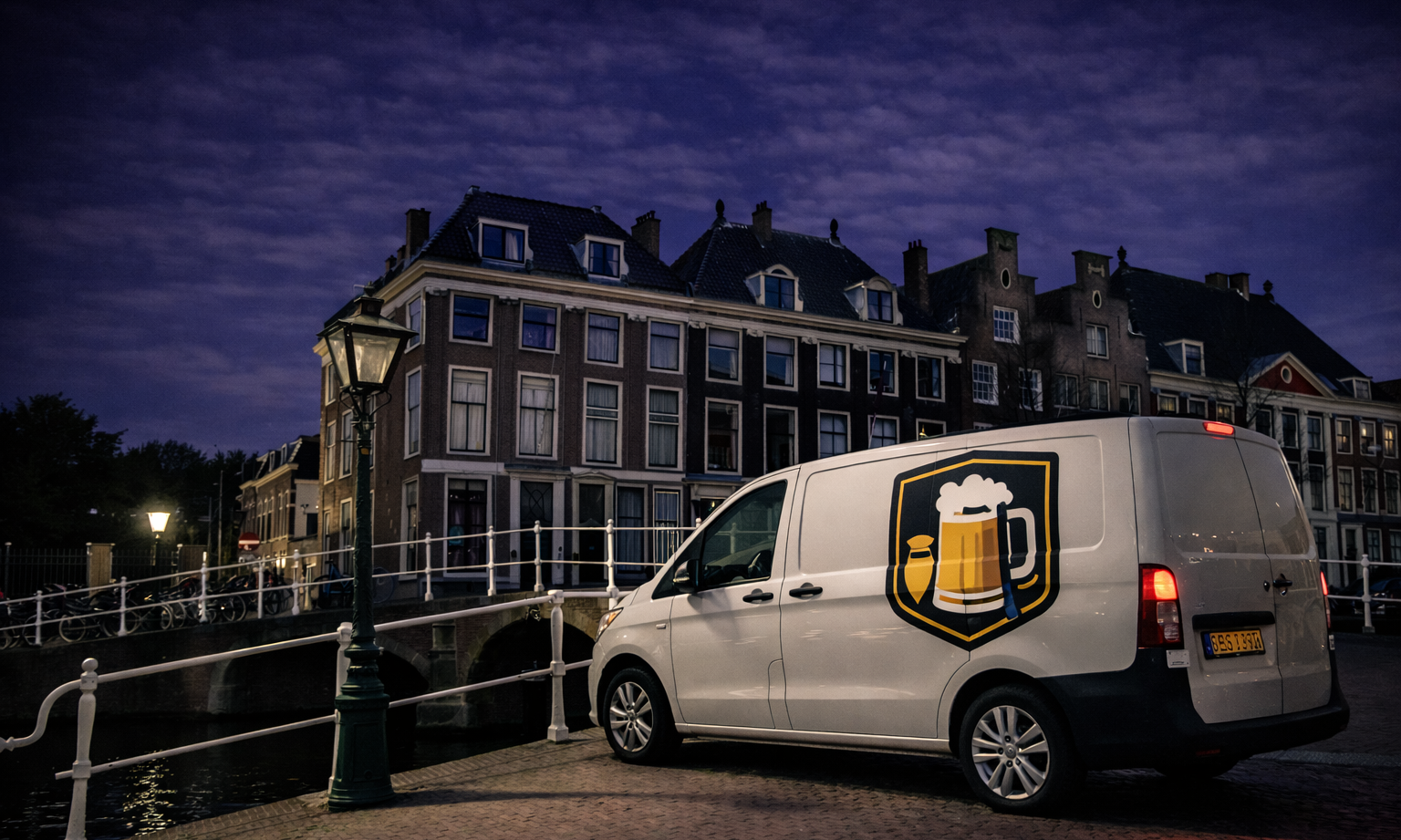 Een bestelbus met bierlogo geparkeerd bij een gracht en historische panden bij avondlicht.