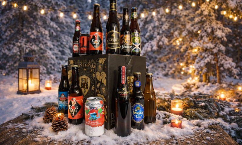 Bierpakket van twaalf bieren en kaarsen op een besneeuwde tafel in een winterse setting.