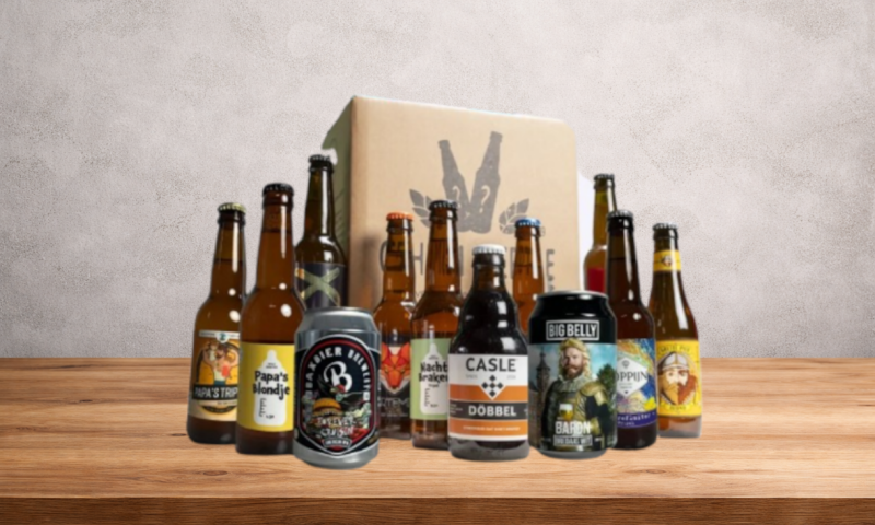 Assortiment van twaalf verschillende bieren voor Vaderdag met een kartonnen doos op de achtergrond.