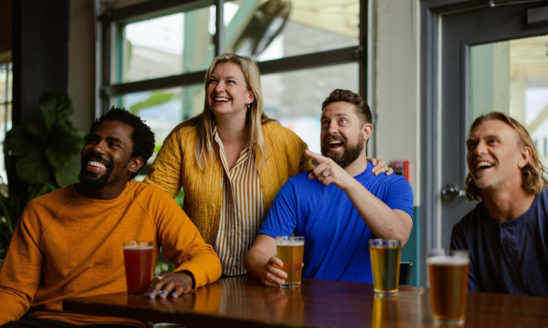 Genieten van sport op TV terwijl je aan tafel zit bier te drinken / Foto: Unsplash