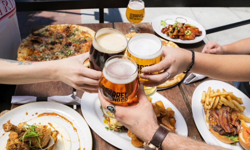 Proosten met bier boven een tafel vol eten