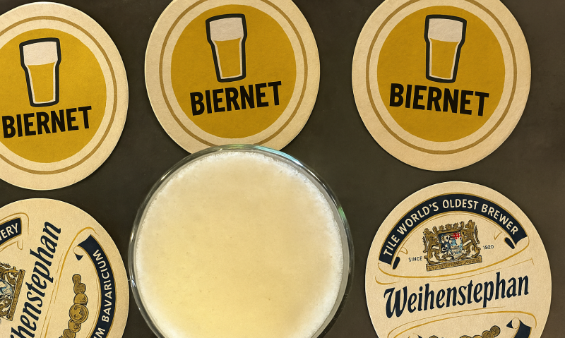 Glas bier van boven met verschillende bierviltjes