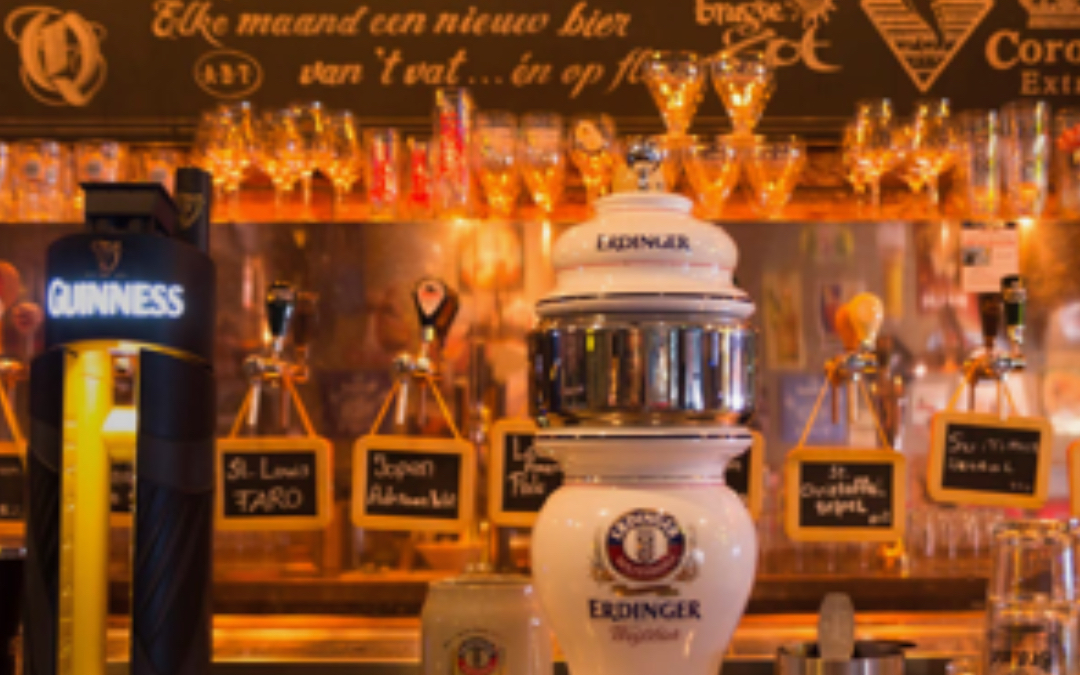 Biertaps en glazen in een Nederlandse kroeg met sfeerverlichting.