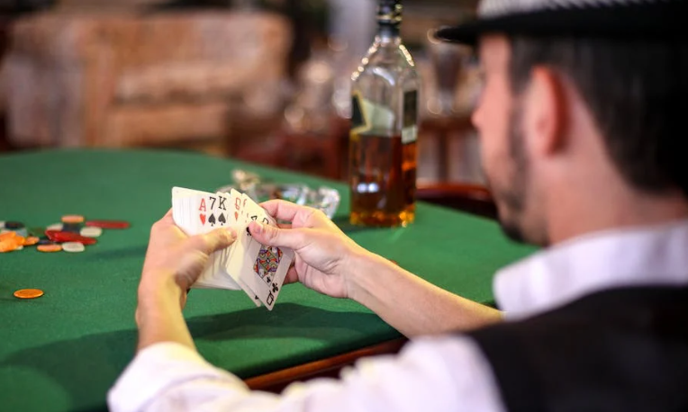 Man aan tafel in het casino met kaarten in de hand Man aan tafel in het casino met kaarten in de hand