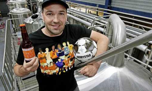 Brouwer van Brouwerij Bier en Ballen in de brouwerij met flesje bier en voetbal in de hand