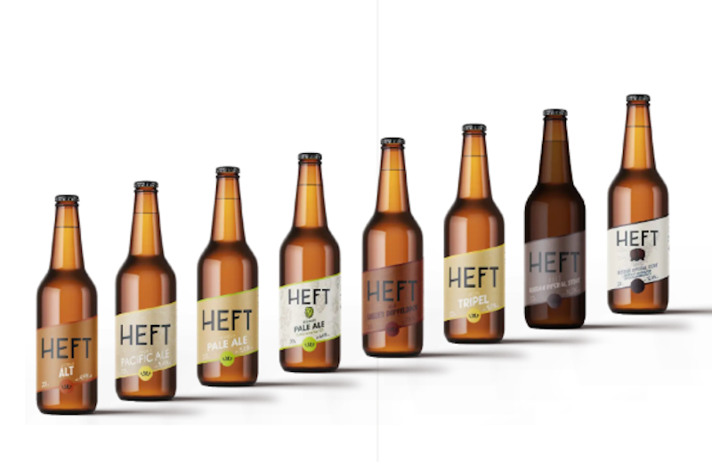 Een rij van zeven flesjes Heft bier, elk met een ander etiket en type bier.