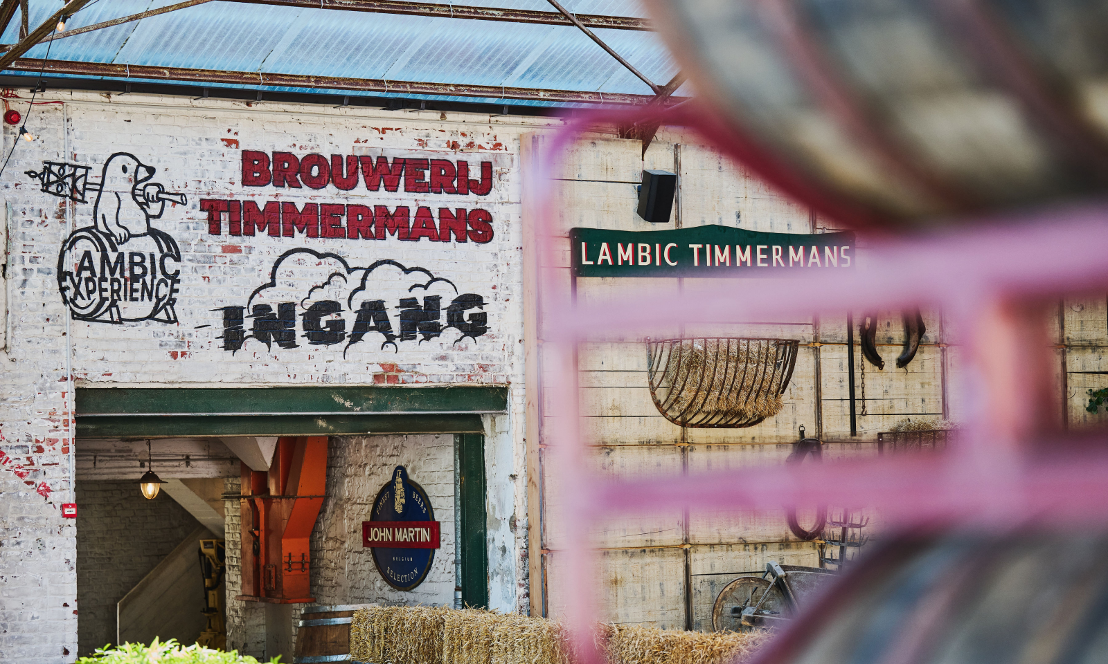 Ingang van Brouwerij Timmermans met muurschilderingen en borden.