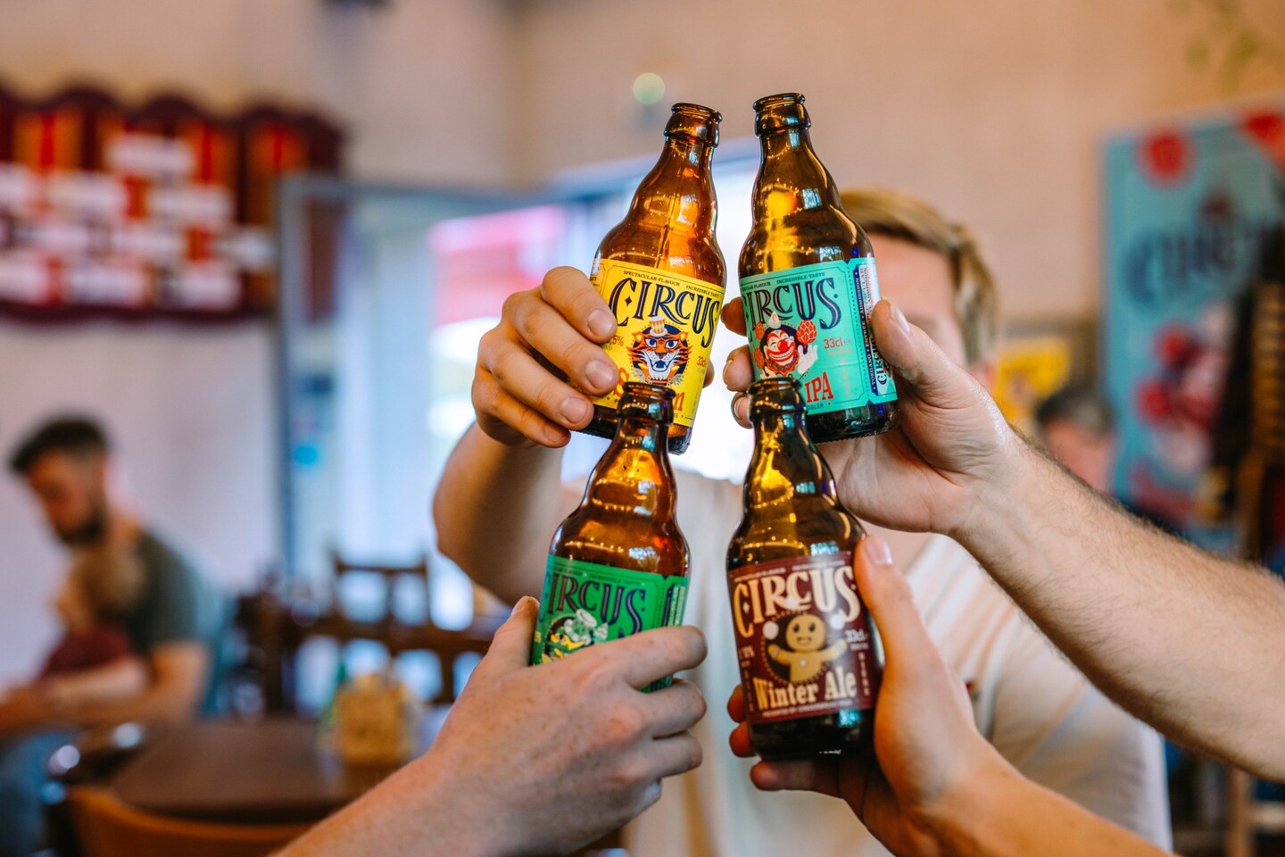 Vier handen klinken met flesjes Circus Saison, Session IPA, Herb Tripel en Winter Ale.