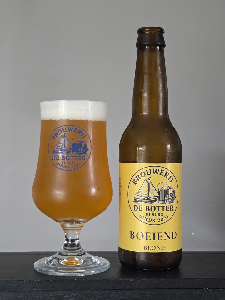 Flesje Boeiend Blond naast een tulpglas met troebel blond bier en een schuimkraag.