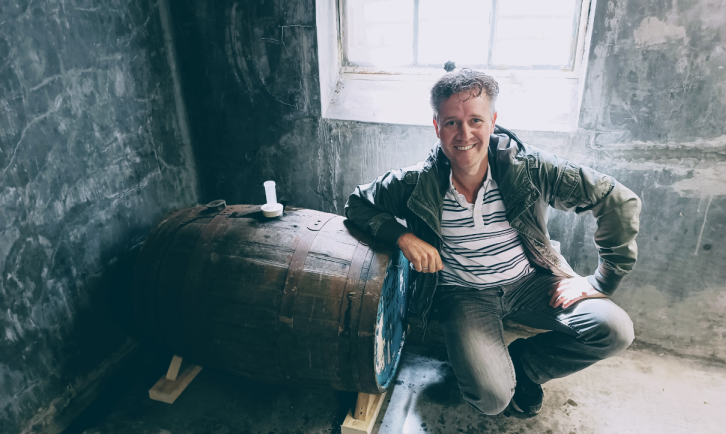Erik van Brouwerij 't Hofke bij één van zijn vaten