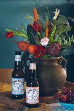 Valentijnsboeket van Lowlander in een vaas met bier ervoor