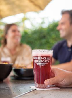 Eylenbosch Oude Kriek glas met twee mensen op de achtergrond