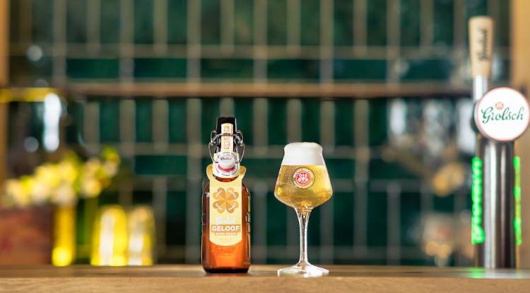 Grolsch Geloof bruine beugelfles en glas op de bar