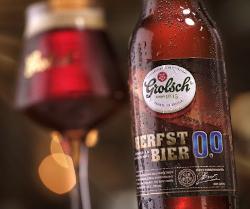 Grolsch Herfstbier 0.0% flesje op de voorgrond en gevuld proeverij glas op de achtergrond