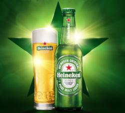 Heineken flesje en bierglas voor de groene ster met zonlicht wat er langs schijnt
