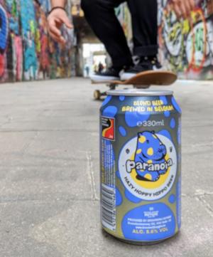 Paranoia blikje met skateboarder erachter