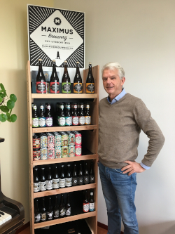 Ton Tuijten van de Maximus Brouwerij voor een kast vol maximus bieren