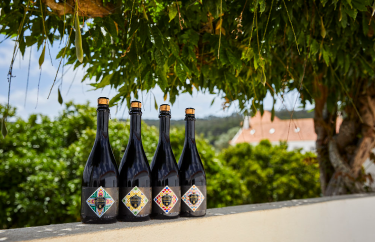 Vier Grand Prestige Vatgerijpt 2021 flessen onder een boom in portugal