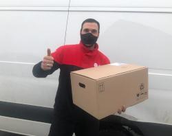 Man voor een busje met een doos Westvleteren Trappist in de hand