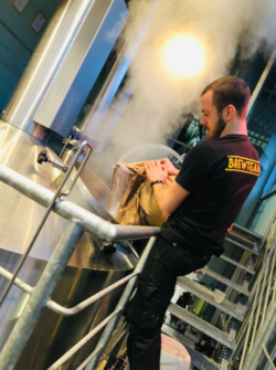 Brouwer voegt mosterd toe tijdens het brouwproces voor de Zaanse Mosted Tripel