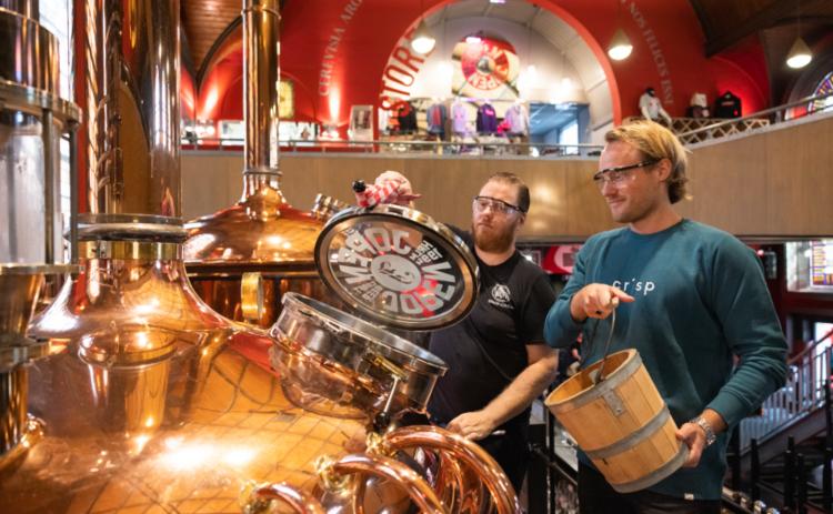 Mannen voegen emmertarwe toe aan de ketel bij de Jopen Brouwerij