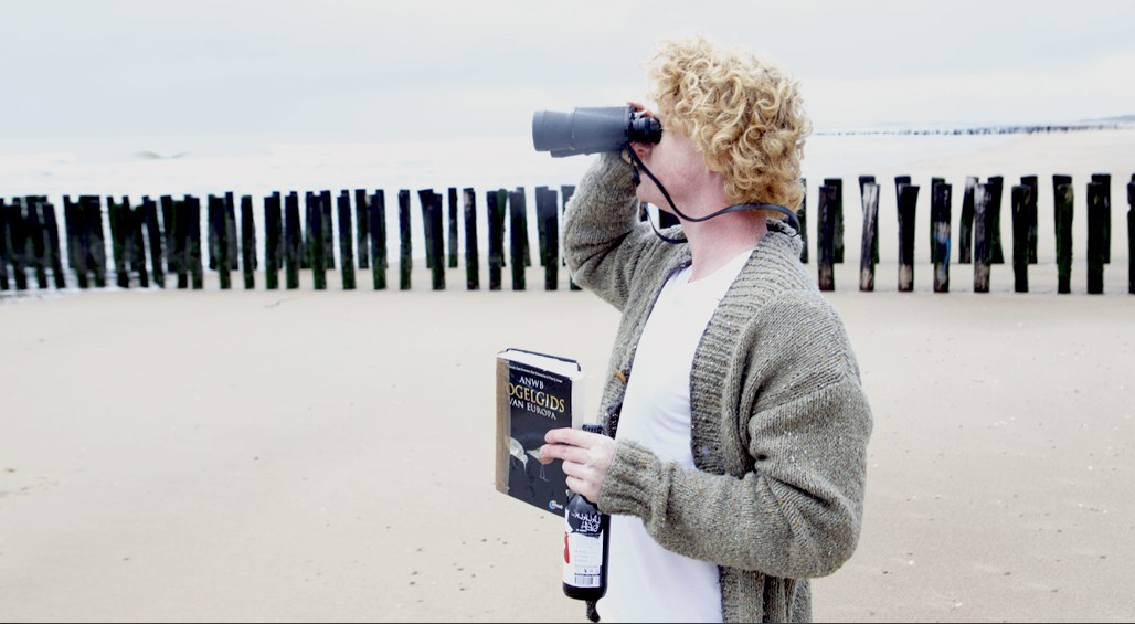 Ralph van Bemmel van Bird Brewery op het strand met verrekijker