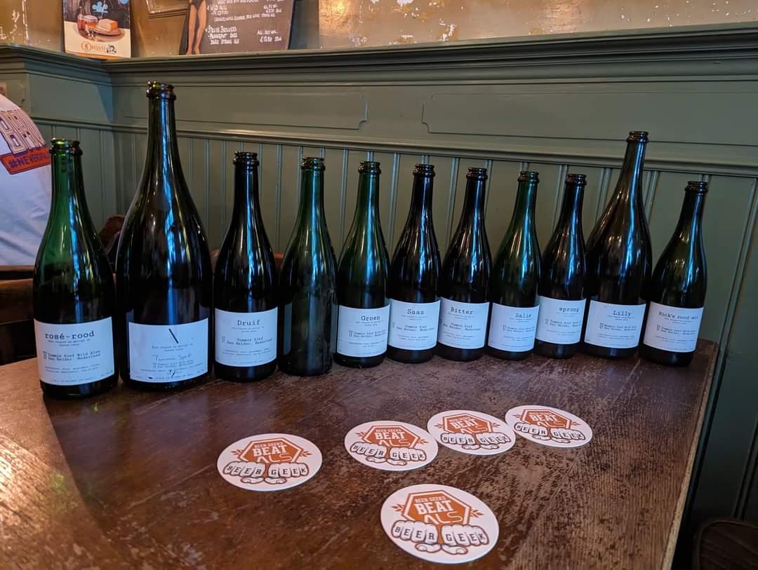 Diverse flessen bier van Tommie Sjef op een tafel met bierviltjes van Beer Geeks Beat ALS