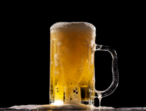 Bierpul die overstroomt met bierschuim