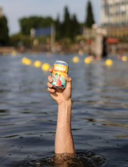 blikje IPGAY bier vastgehouden door iemand onder water