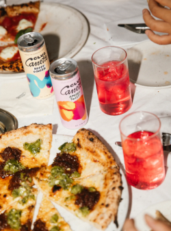 club canette drankjes in blikje en glazen bij twee pizza's