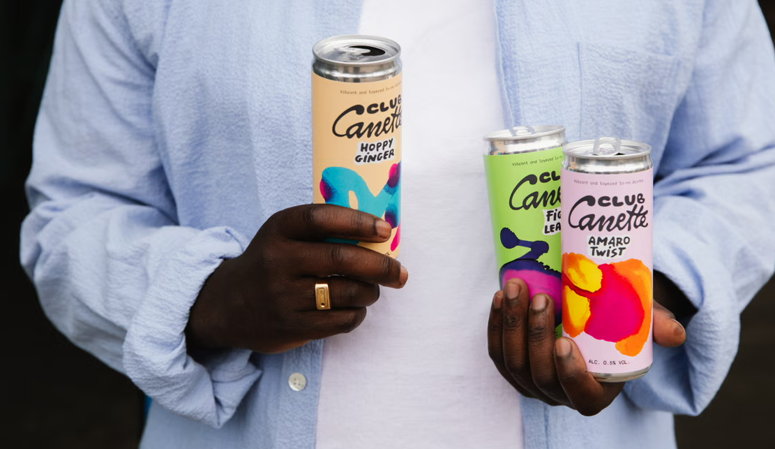 Man met houdt drie club canette blikjes vast