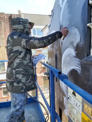Paul Watty aan het werk met de struisvogels op de gevel van Rijslust in Tilburg