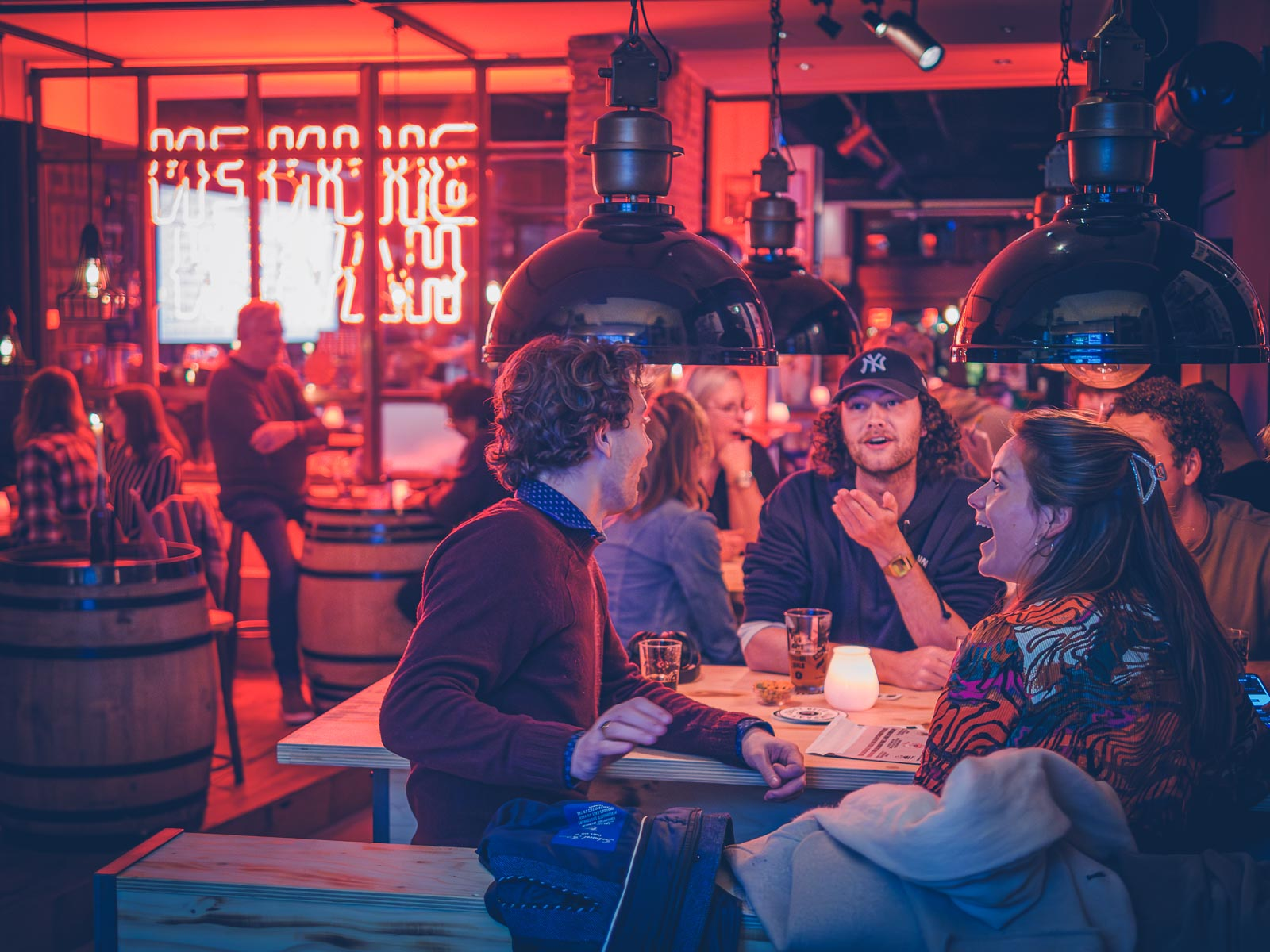Twee mannen en een vrouw genieten bij Kompaan Binnenhaven