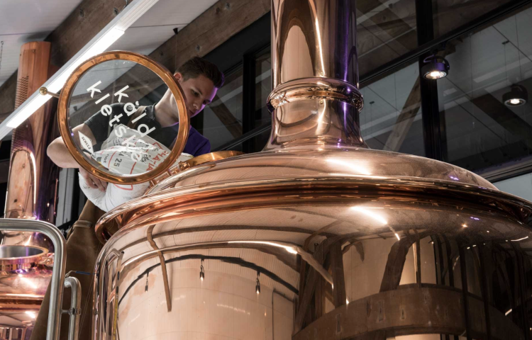 Man gooit ingrediënten in de brouwketel bij Brouwerij Dockum Kald Kletske