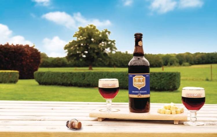 Chimay Grande Reserve fles en glazen buiten op tafel