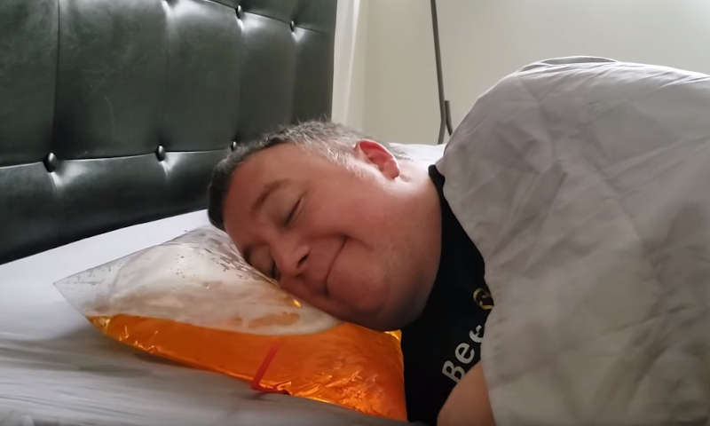 Man slaapt heerlijk op bierkussen // Screenshot Youtube