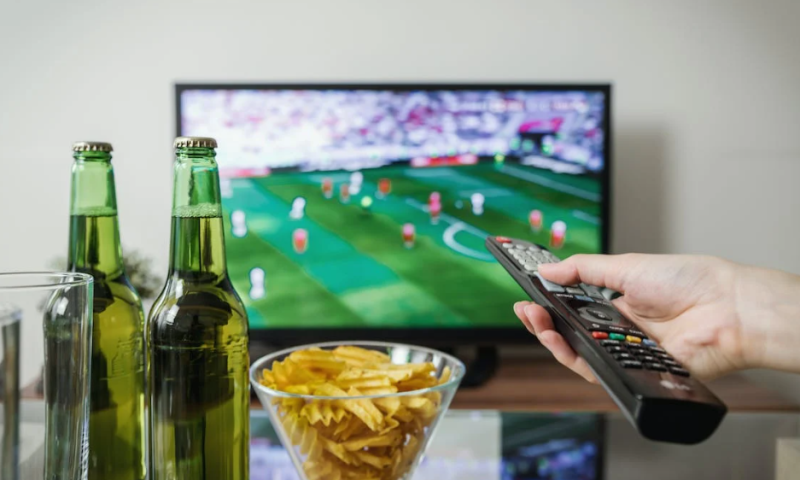 Voetbal kijken op tv met een biertje erbij